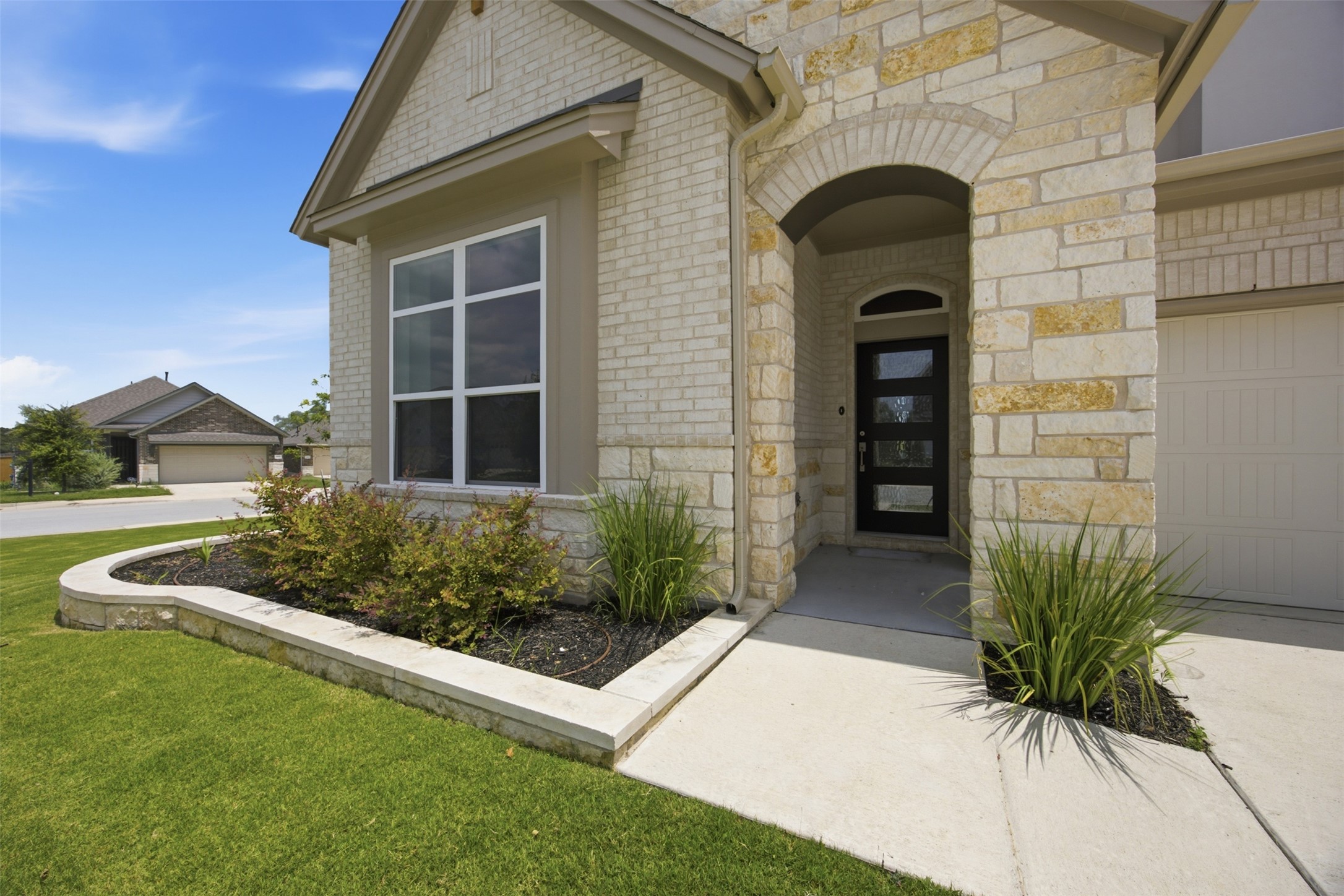2101 Little Snake Way Georgetown, TX 78633 - Photo 5 of 37 A graceful home entrance showcases a blend of brick and stone masonry with a contemporary front door.