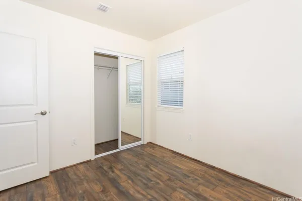 a view of an empty room with wooden floor