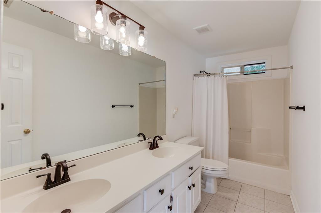 1446 Chadwick Ridge Court Lawrenceville, GA 30043 - Photo 30 of 54 a bathroom with a sink a toilet and shower