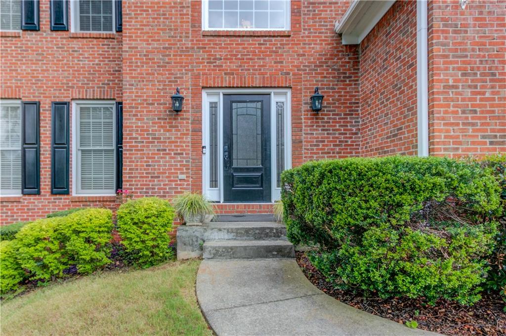 1446 Chadwick Ridge Court Lawrenceville, GA 30043 - Photo 4 of 54 a front view of a house with a yard