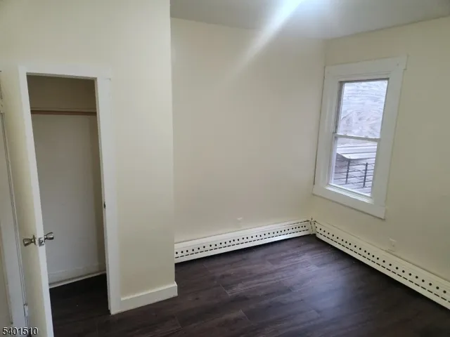 an empty room with a hardwood and a window