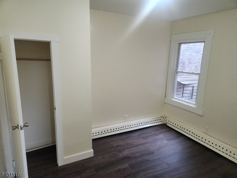 343 Market Street, Unit 3R Paterson, NJ 07501 - Photo 2 of 7 an empty room with a hardwood and a window