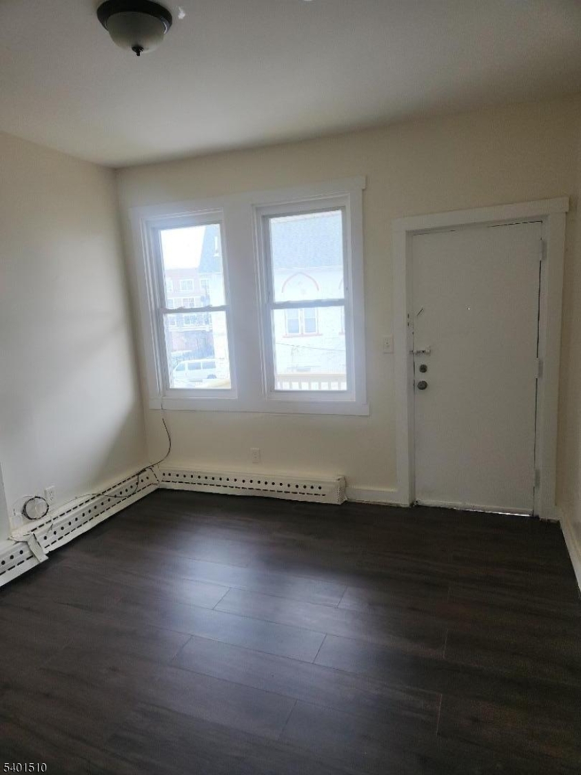 343 Market Street, Unit 3R Paterson, NJ 07501 - Photo 5 of 7 an empty room with wooden floor and windows
