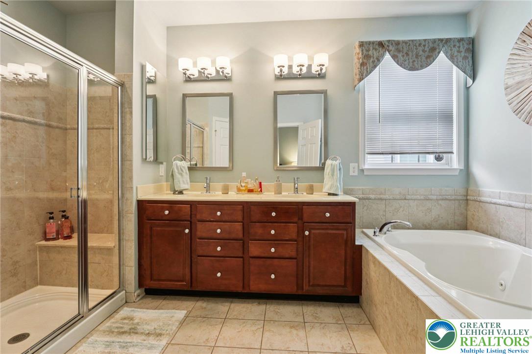 2113 Kingsview Road Lower Macungie Township, PA 18062 - Photo 30 of 62 a bathroom with a tub a double vanity sink and mirror