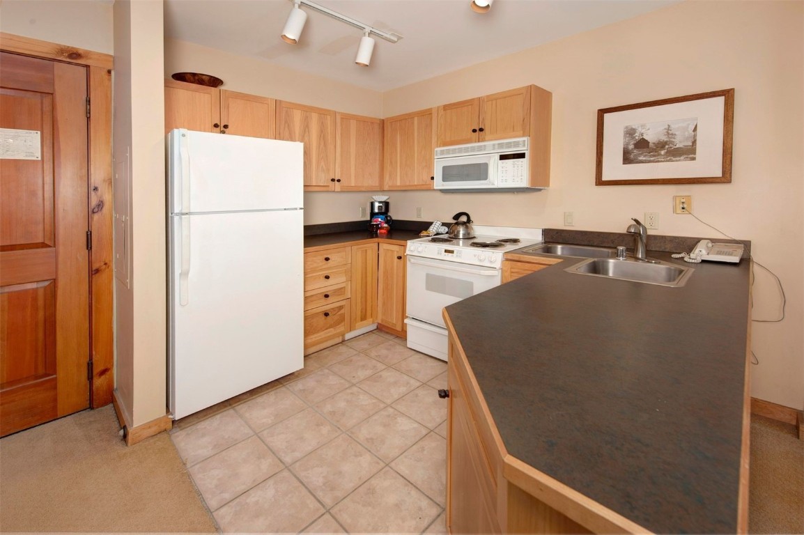 100 Dercum Square, Unit 8371 Keystone, CO 80435 - Photo 6 of 33 a kitchen with stainless steel appliances granite countertop a refrigerator a stove a sink a microwave and a refrigerator
