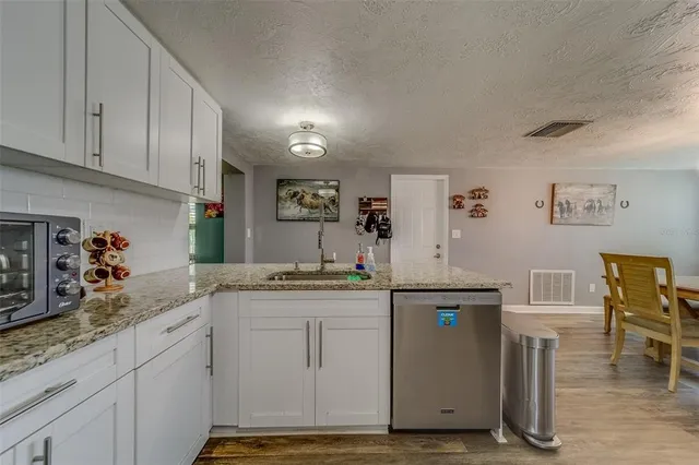 a kitchen with a dining table chairs and refrigerator