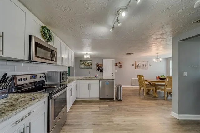 a kitchen with a refrigerator sink and cabinets