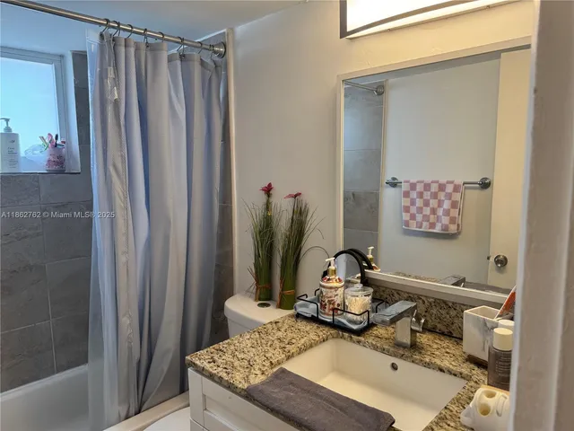 a bathroom with a shower curtain and a window