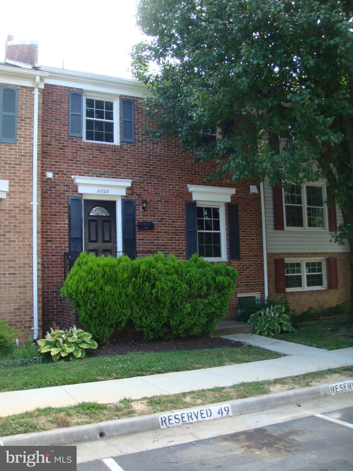 a front view of a brick house with a yard