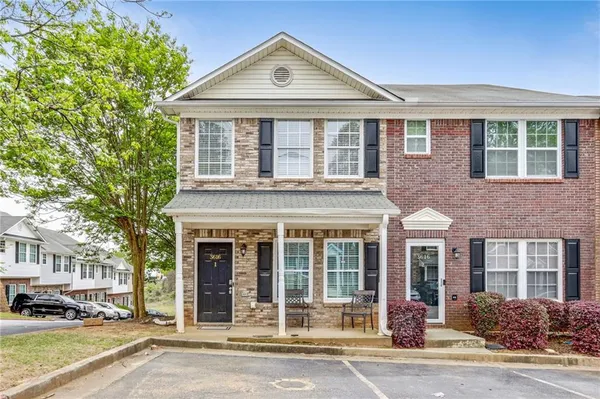 a front view of a building with a garden and plants