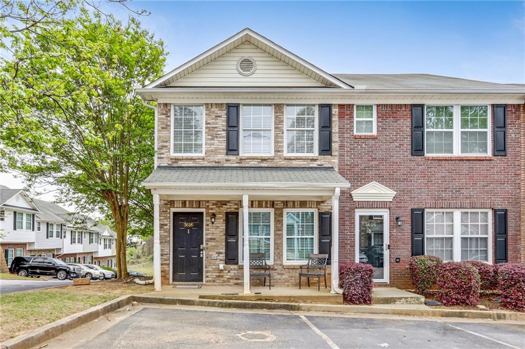 a front view of a building with a garden and plants