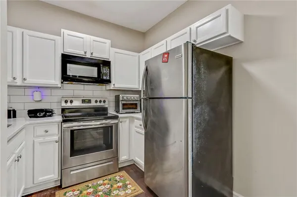 a kitchen with stainless steel appliances a refrigerator stove and microwave