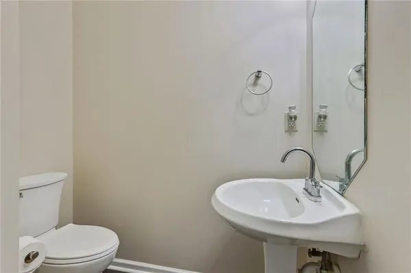 a bathroom with a sink a toilet and a mirror