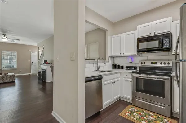 a kitchen with stainless steel appliances a stove microwave and sink