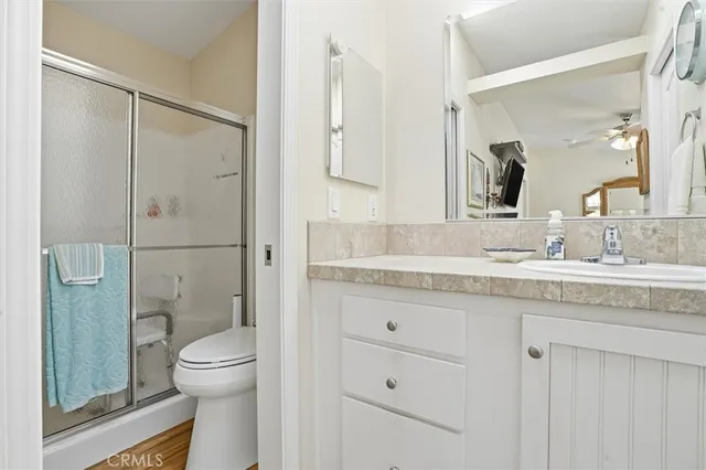 a bathroom with a granite countertop sink toilet and shower