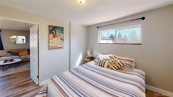 a bedroom with bed and wooden floor