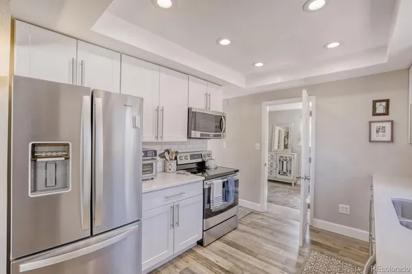 a kitchen with stainless steel appliances a refrigerator sink and microwave