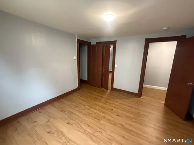 an empty room with wooden floor and closet