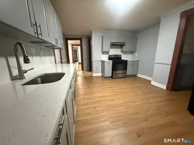 a kitchen with granite countertop a refrigerator and a sink