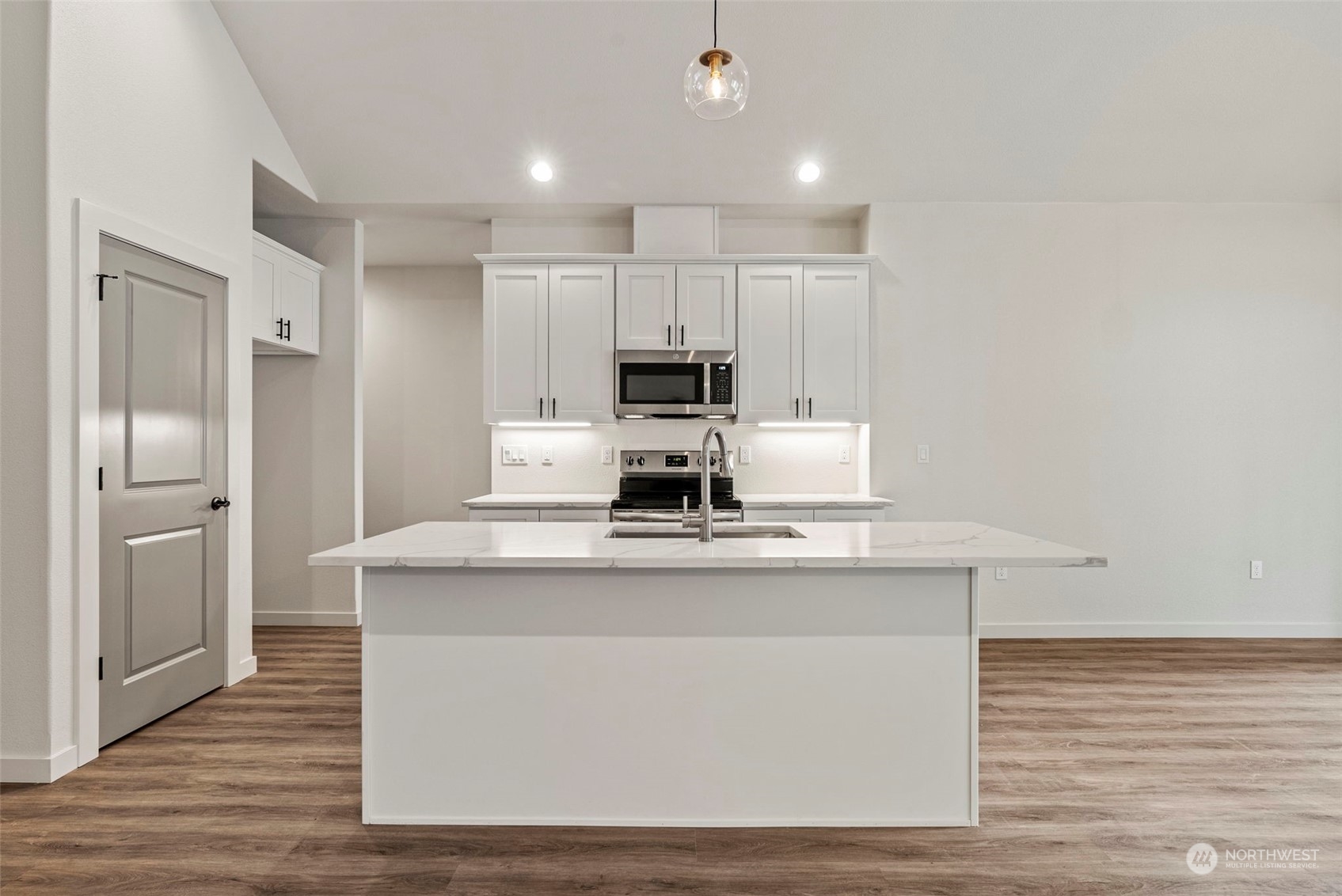 147 Hunter Road Longview, WA 98632 - Photo 10 of 31 a kitchen with kitchen island a sink a stove a refrigerator and white cabinets