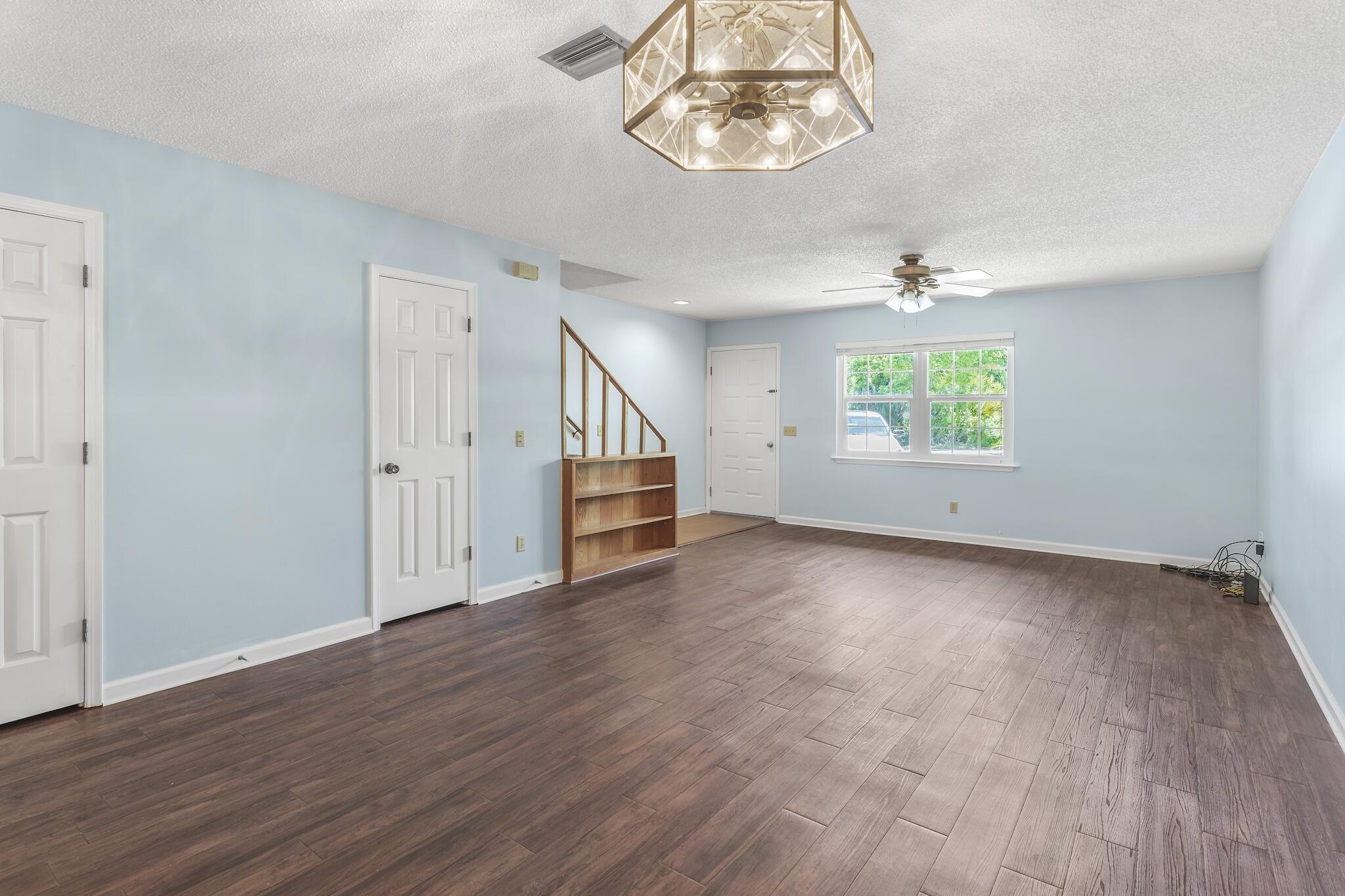 241 Ellis Road, Unit 2 Miramar Beach, FL 32550 - Photo 11 of 17 an empty room with wooden floor chandelier and windows