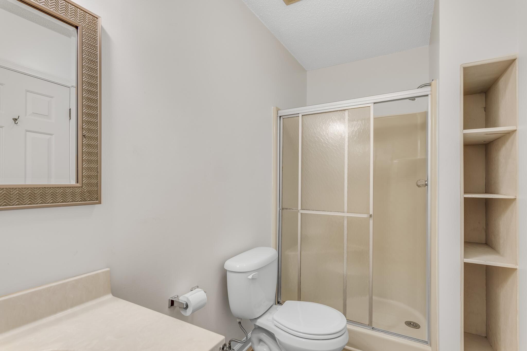 241 Ellis Road, Unit 2 Miramar Beach, FL 32550 - Photo 16 of 17 a white toilet sitting next to a bathroom sink