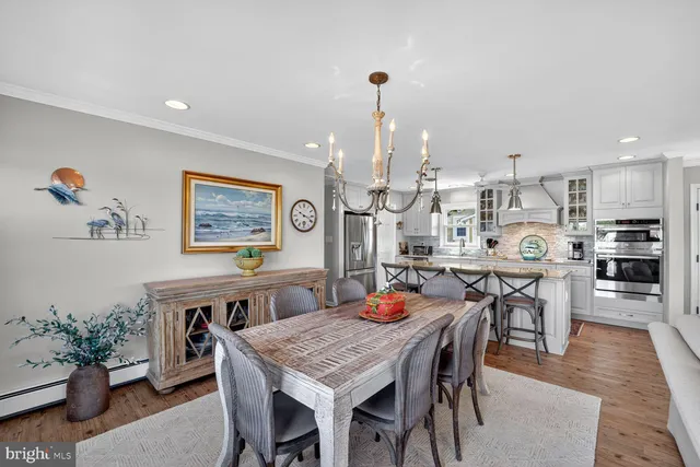 a dining area with furniture a rug and kitchen view