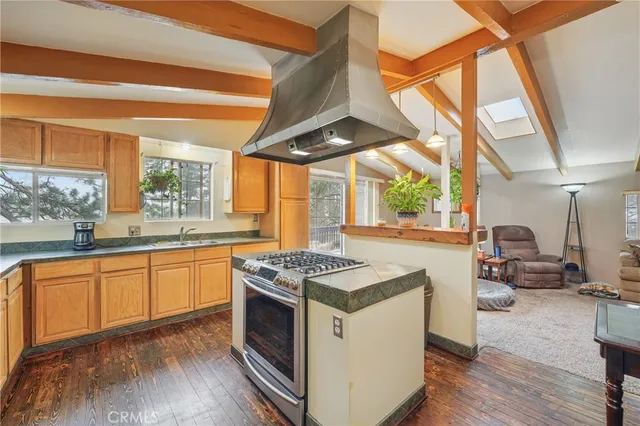 a kitchen with granite countertop a stove a sink and a refrigerator