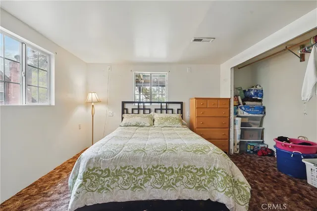 a bed sitting in a bedroom and chair