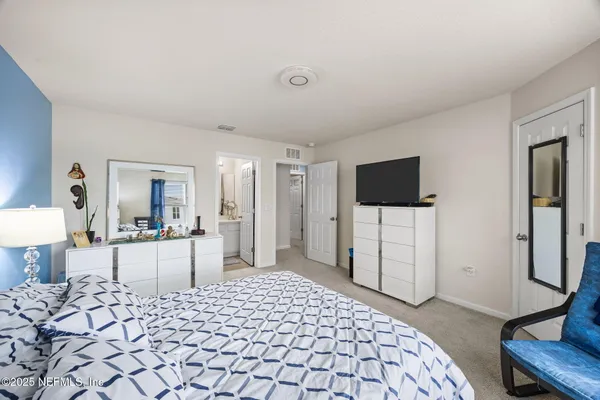 a bedroom with a bed and a flat tv screen in it