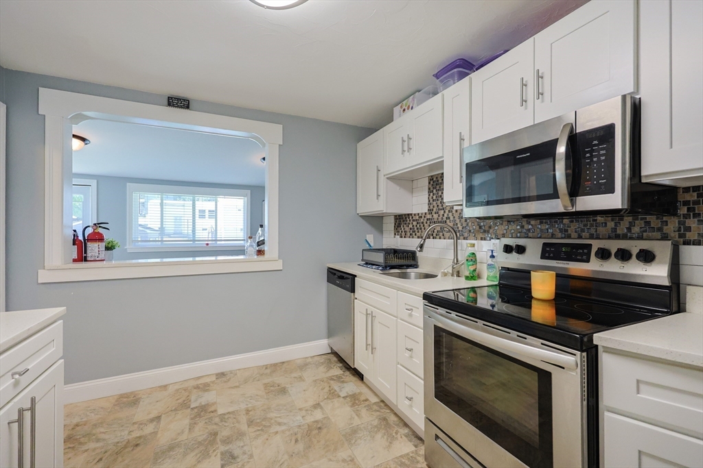 23 Superior Road Worcester, MA 01604 - Photo 23 of 32 a kitchen with stainless steel appliances granite countertop a stove a sink and a microwave
