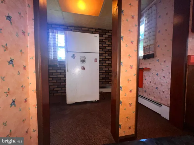 a room with table chairs and a refrigerator