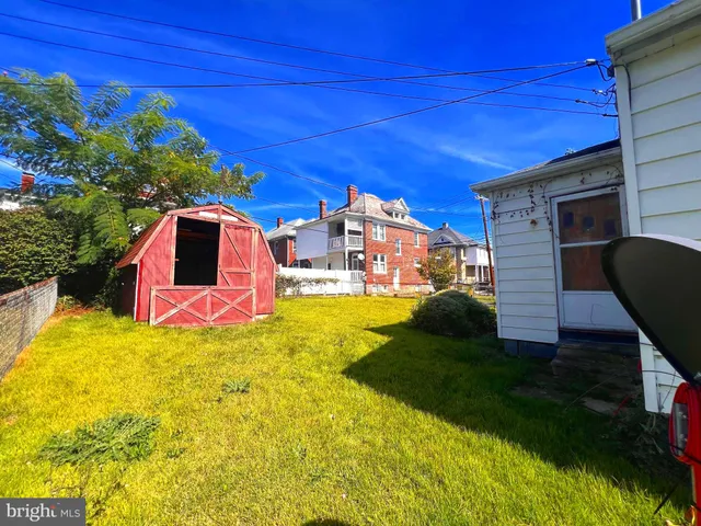 a view of a backyard with plants and brick wall