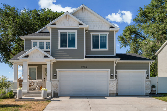2706 West Maple Street, Unit 285 Mapleton, UT 84664 - Photo 1 of 36 Two-story residence featuring a covered front porch, white column supports, and a two-car garage with an additional single-car garage