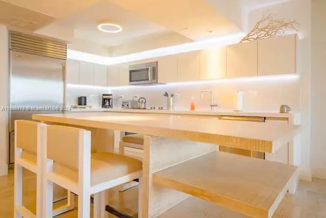 a kitchen with stainless steel appliances granite countertop a sink and a refrigerator