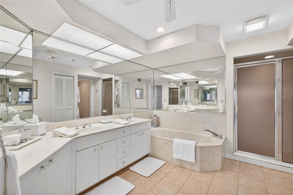 11000 Placida Road, Unit 2804 Placida, FL 33946 - Photo 15 of 56 a bathroom with a double vanity sink a mirror and a bathtub