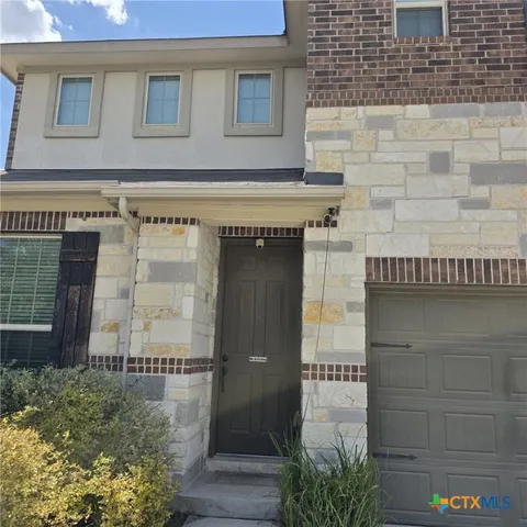an empty room with windows and chandelier fan