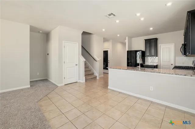 a kitchen with stainless steel appliances granite countertop a refrigerator and a sink