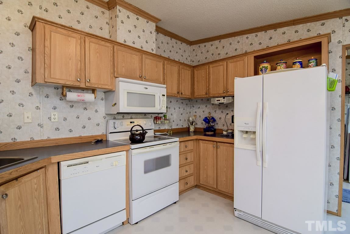 10129 Smith Road Middlesex, NC 27557 - Photo 11 of 25 a kitchen with stainless steel appliances granite countertop a refrigerator sink and white cabinets