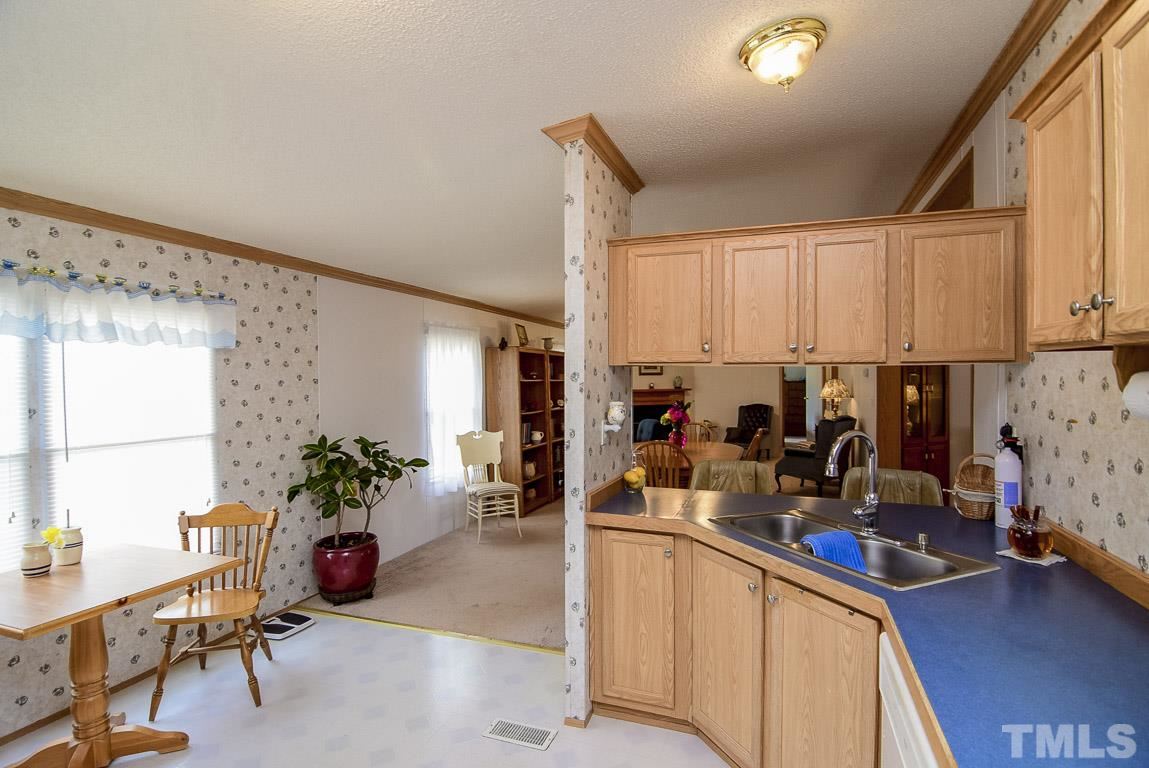 10129 Smith Road Middlesex, NC 27557 - Photo 13 of 25 a kitchen with sink refrigerator and cabinets