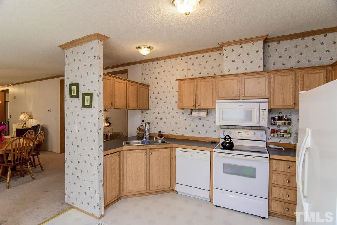 10129 Smith Road Middlesex, NC 27557 - Photo 14 of 25 a kitchen with cabinets stainless steel appliances and wooden floor