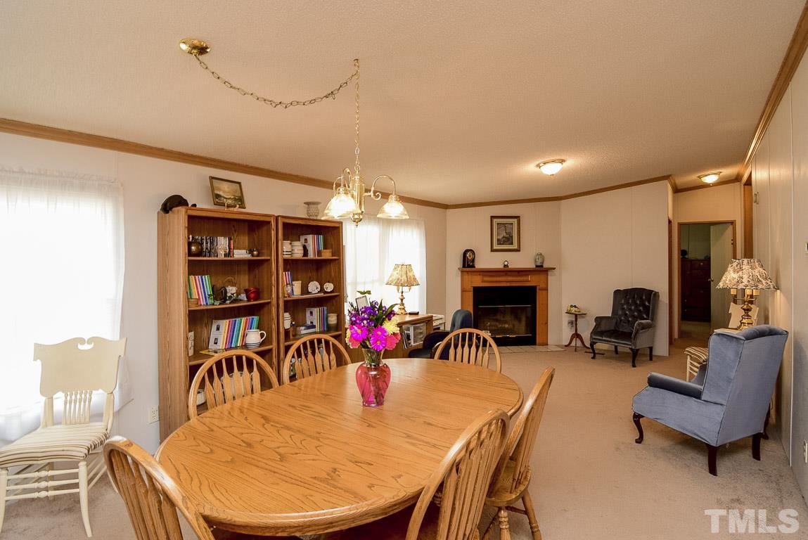 10129 Smith Road Middlesex, NC 27557 - Photo 15 of 25 a view of a dining room with furniture wooden floor and a fireplace