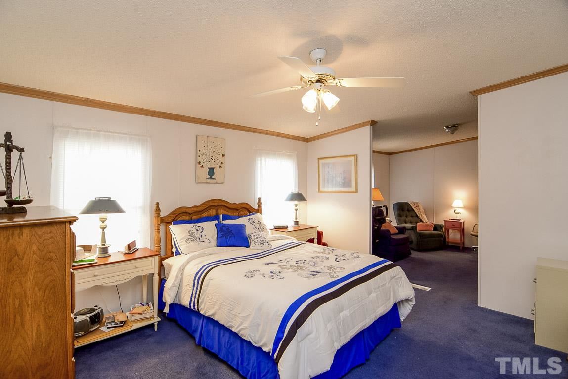 10129 Smith Road Middlesex, NC 27557 - Photo 19 of 25 a bedroom with bed and a chandelier