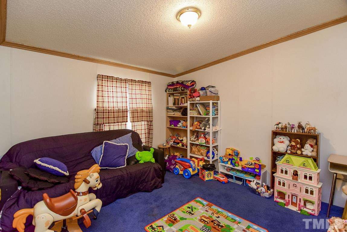 10129 Smith Road Middlesex, NC 27557 - Photo 20 of 25 a living room with toys and a book shelf