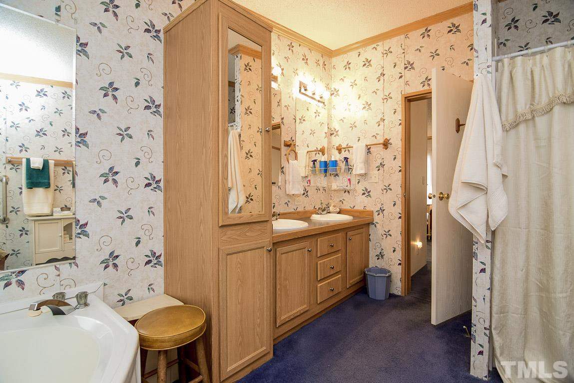 10129 Smith Road Middlesex, NC 27557 - Photo 24 of 25 a bathroom with a granite countertop sink toilet a mirror a shower and a bathtub