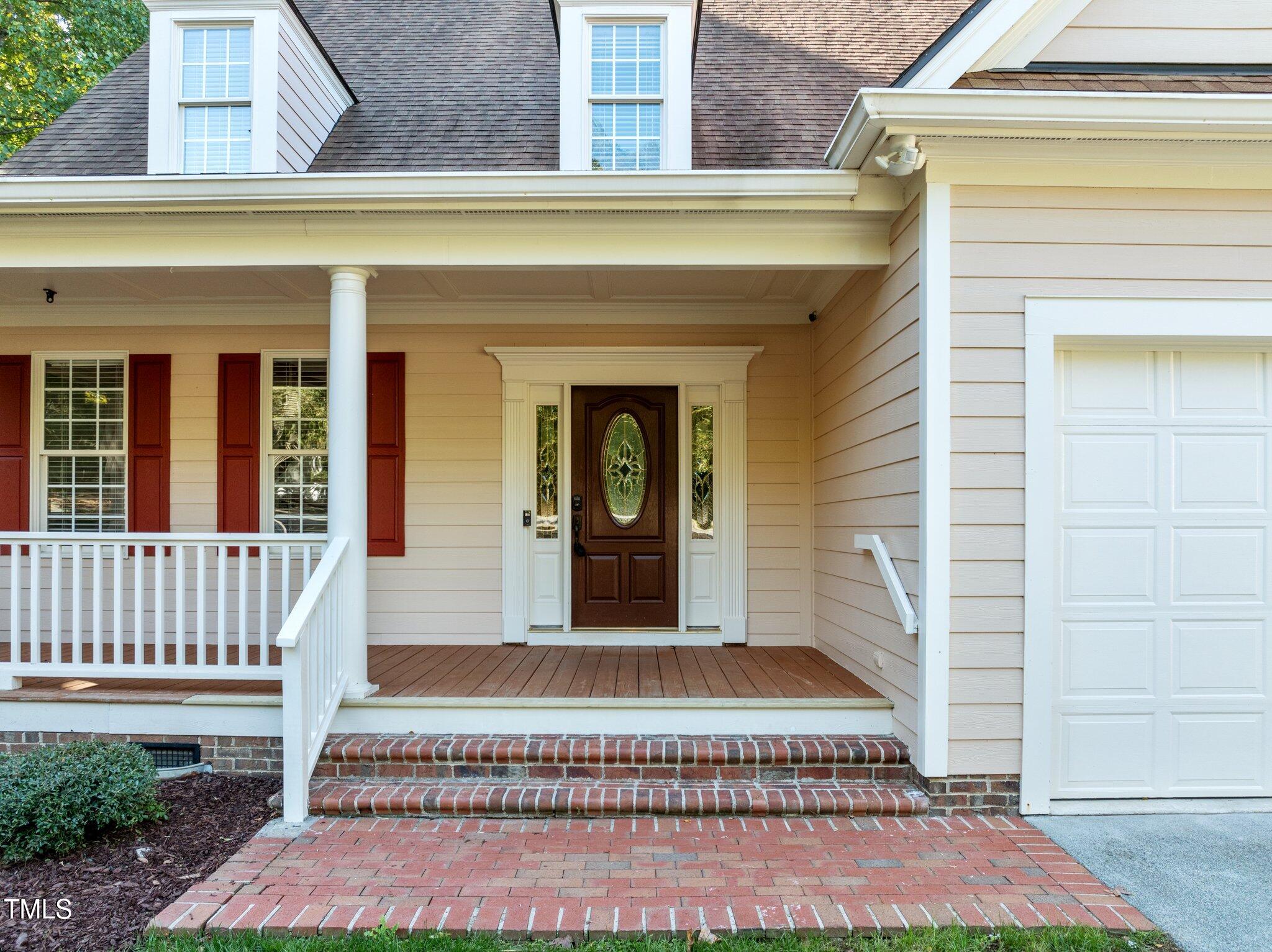 7621 Wilderness Road Raleigh, NC 27613 - Photo 47 of 60 a view of a house with entrance stairs and a yard