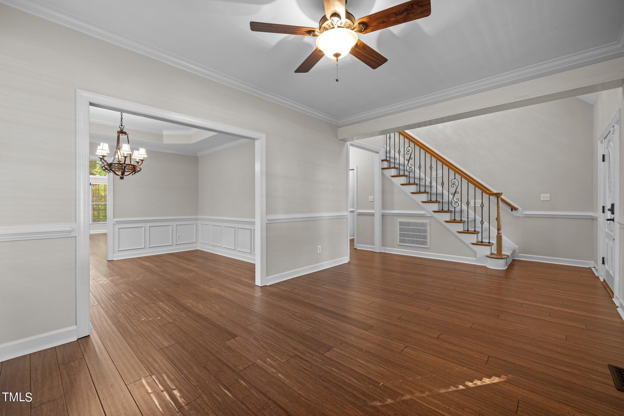 7621 Wilderness Road Raleigh, NC 27613 - Photo 5 of 60 a view of an empty room with wooden floor and a ceiling fan