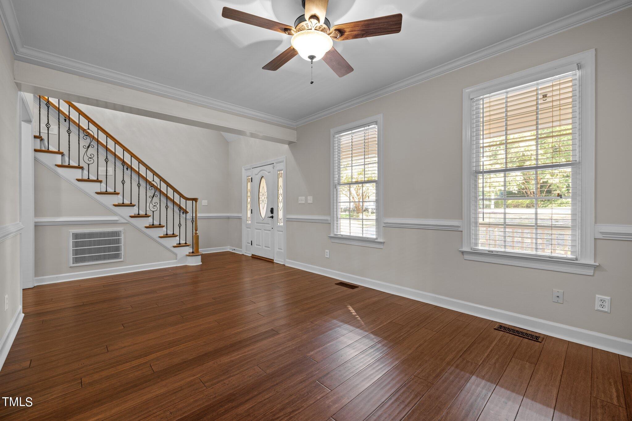 7621 Wilderness Road Raleigh, NC 27613 - Photo 6 of 60 a view of an empty room with wooden floor and a window