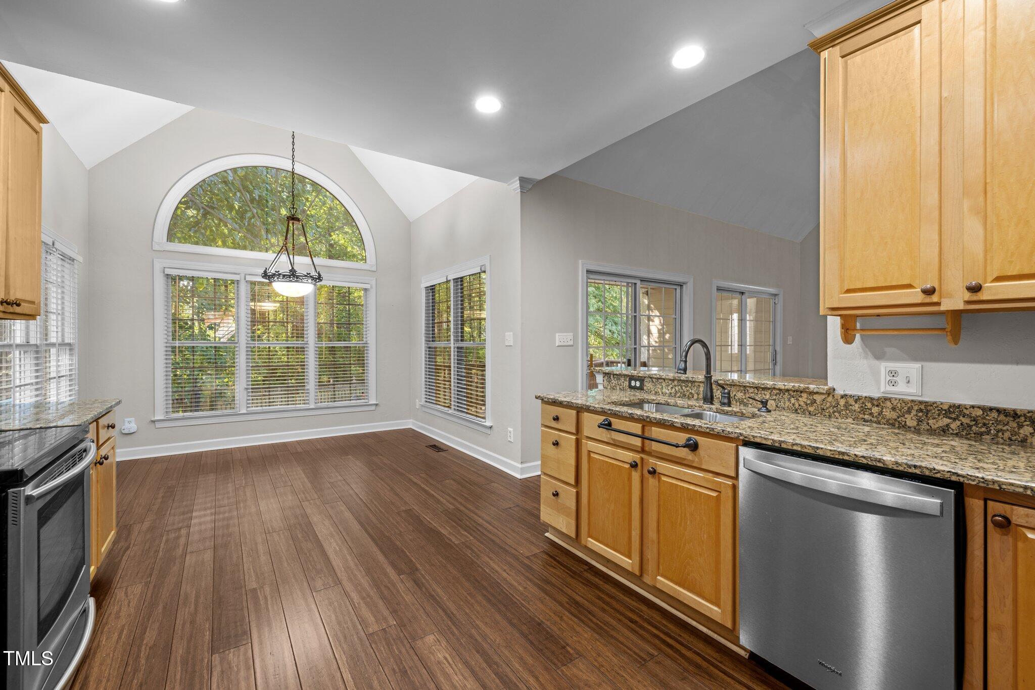7621 Wilderness Road Raleigh, NC 27613 - Photo 10 of 60 a kitchen with stainless steel appliances granite countertop wooden floors and sink