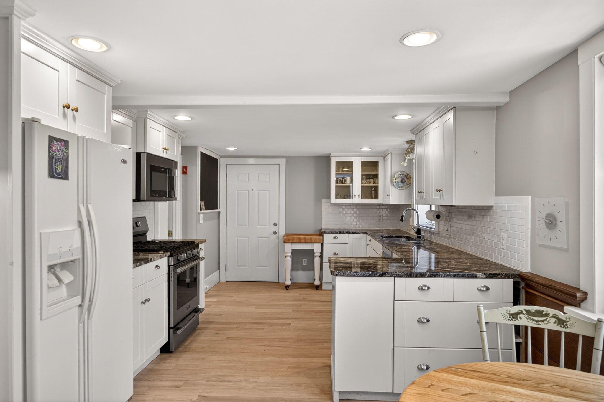 69 County Road Bourne, MA 02532 - Photo 9 of 54 a kitchen with stainless steel appliances kitchen island granite countertop a refrigerator oven a sink dishwasher and white cabinets next to a window